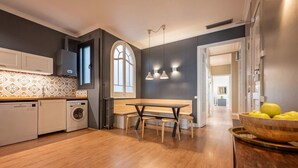 A modern kitchen with a dining area, a washing machine, and a large window. - Sweett | Sepulveda 3C (Barcelona)