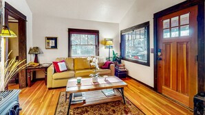 A cozy living room with a sofa, coffee table, and a door with windows.