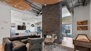 Un intérieur moderne avec un pilier en pierre, un canapé en cuir et une table de billard.