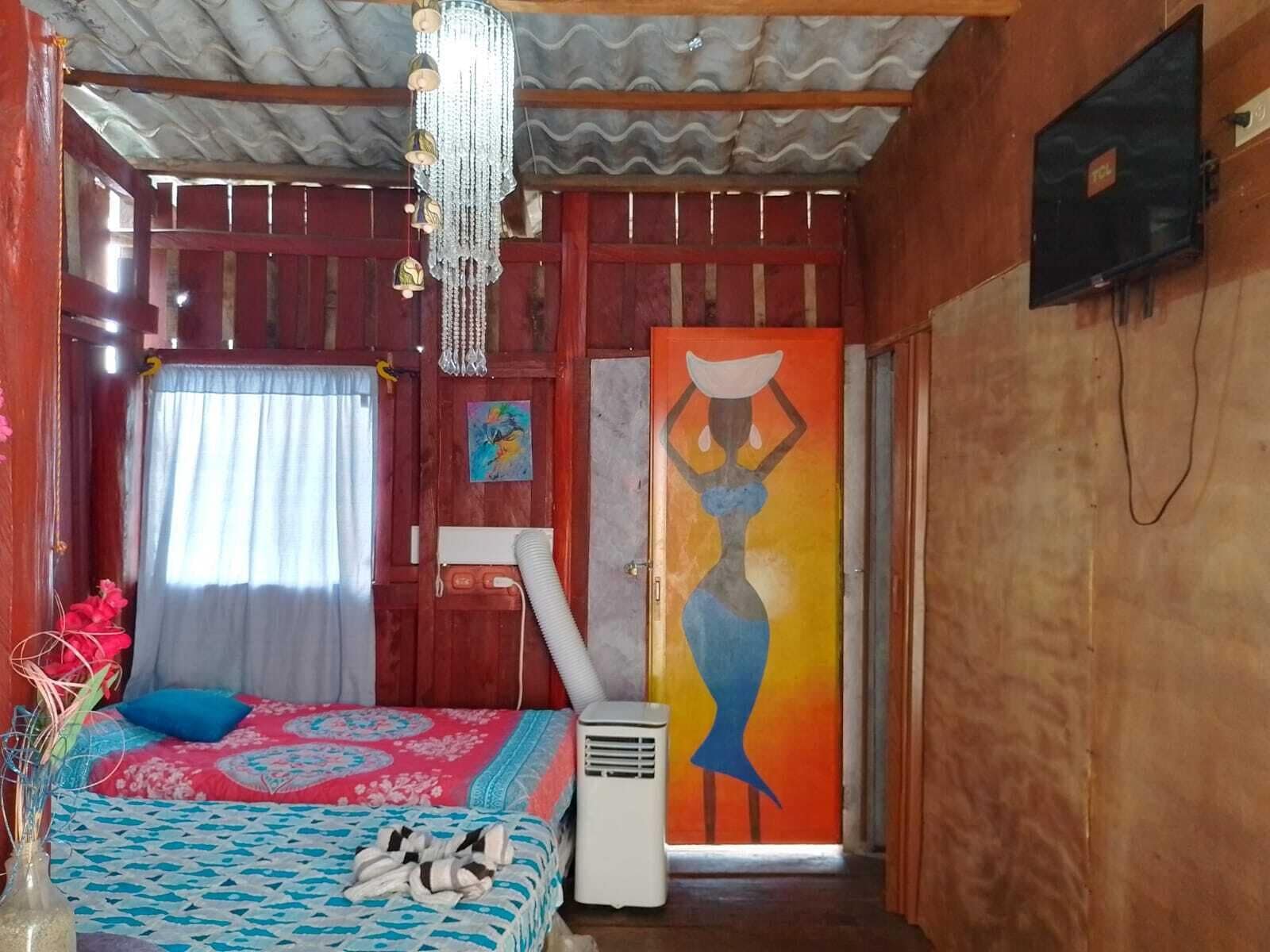 Una habitación con cama, calefacción, un cuadro y televisor.