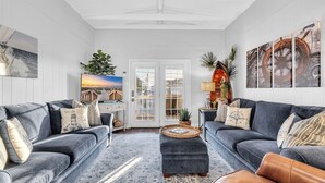 Ein geräumiges Wohnzimmer mit zwei grauen Sofas, einem Couchtisch und einem gemusterten Teppich.