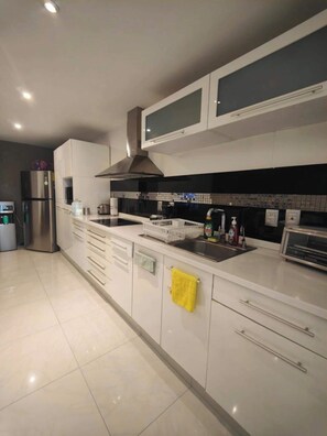 Een koelkast, kookgerei, borden en bestek