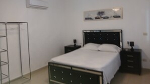 A bedroom with a bed, bedside tables, a wardrobe, and a ceiling light.