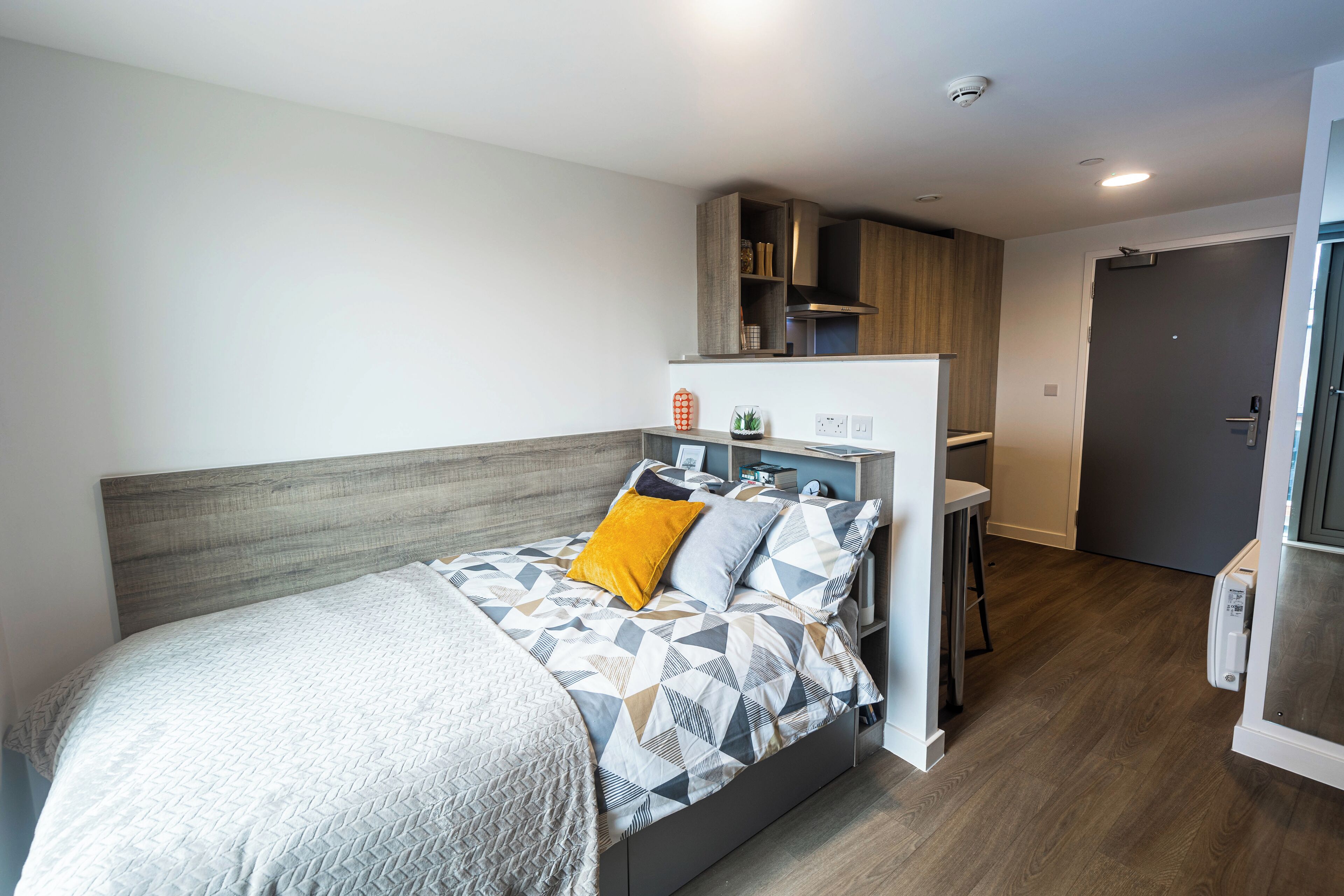Ein modernes Schlafzimmer mit Bett, Nachttischen und einem Einbauschrank.