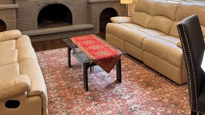A living room with a fireplace, a sofa, a coffee table, and a television.