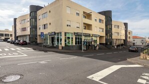 A multi-story building with a ground-floor commercial space, including a bakery and a pharmacy. - Priolo’s Nest - Sunlit Retreat with Free Parking (Unknown)