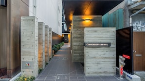 A narrow alleyway with a wooden fence and a sign reading "Comforia IV".