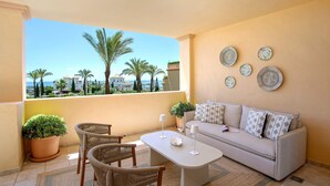 A balcony with wicker furniture, a sofa, and decorative plates. - Genteel Home Flamingos Golf (Seville)