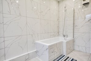 Appartement | Badkamer | Een douche, een haardroger, handdoeken