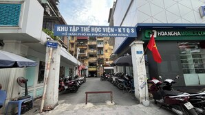 Una calle estrecha con motocicletas estacionadas y un letrero de un proveedor de servicios móviles.