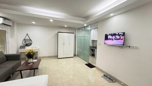 Una sala de estar moderna con un sofá, una mesa de centro, un televisor y un armario.