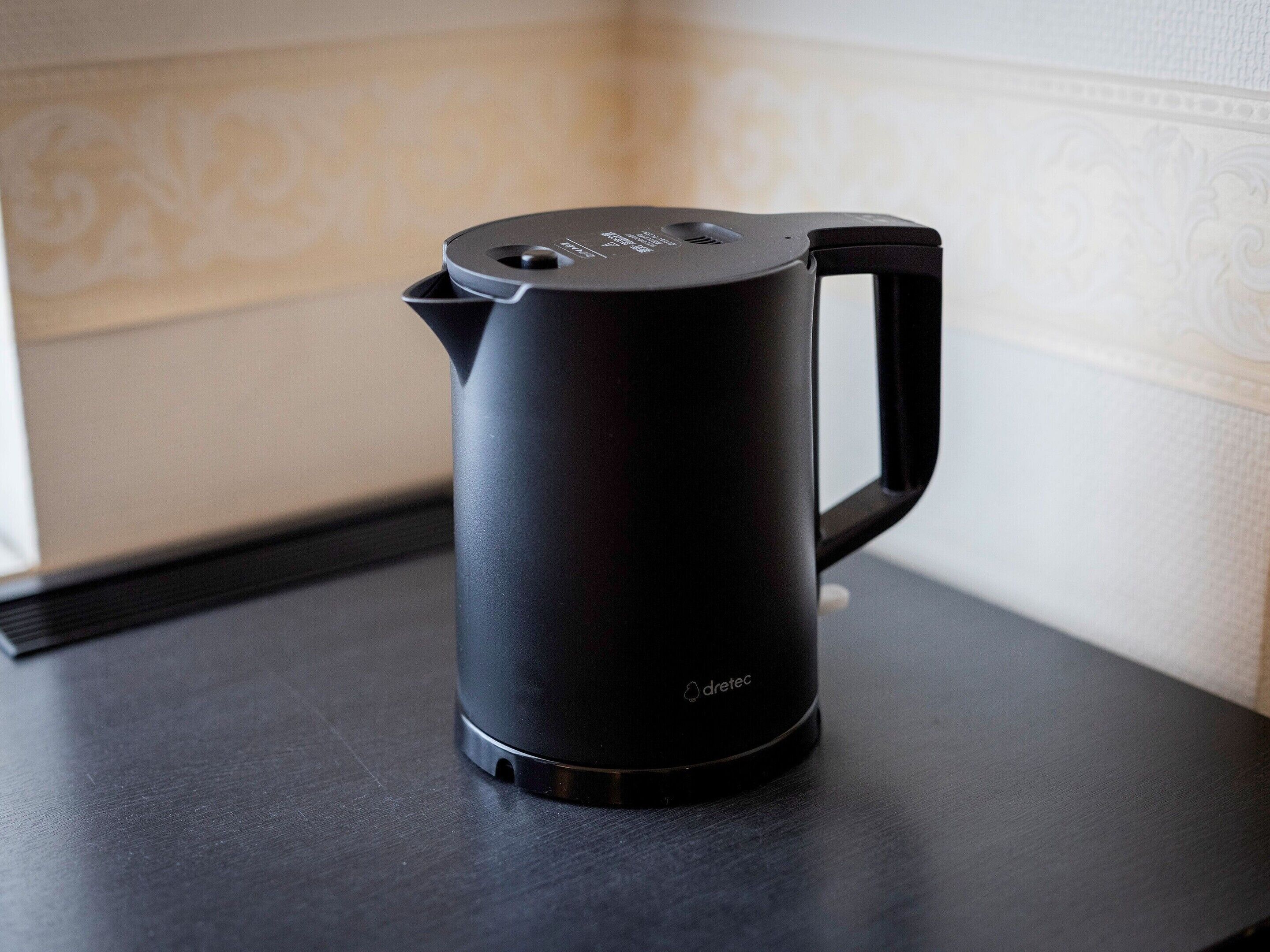 A black electric kettle on a dark countertop.