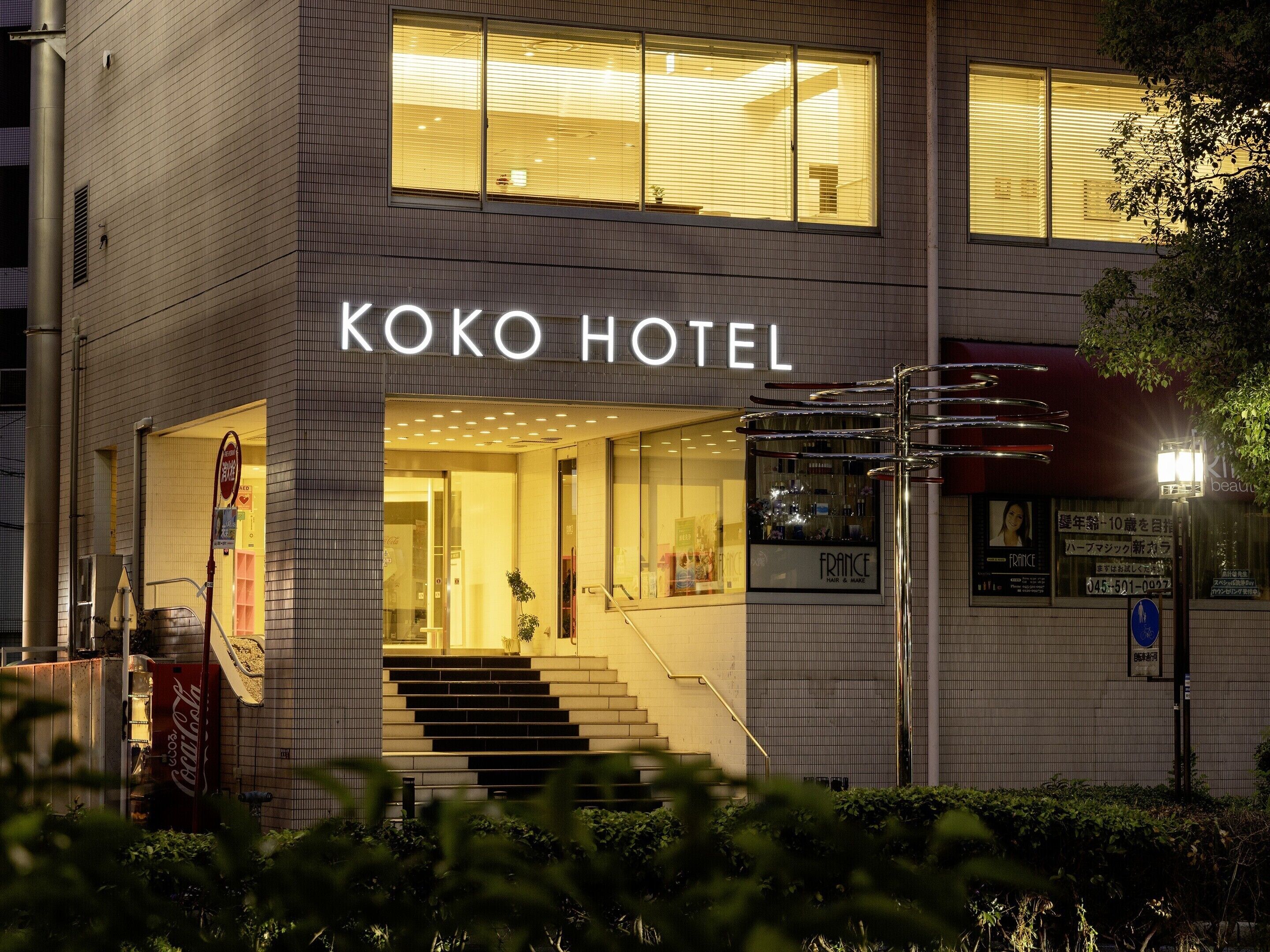 A building with a sign reading 'KOKO HOTEL' and a staircase leading to the entrance.
