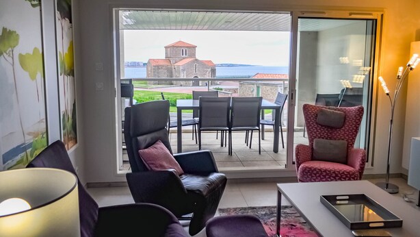 A modern living room with a view of a church and sea. - Vue Mer Panoramique  Confort Moderne (Les Sables-d´Olonne)