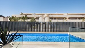 A swimming pool with a view of a building in the background. - Perfect getaway with balcony and pool (Cabanas de tavira)