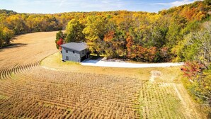 A rural landscape with a small building surrounded by fields and autumn-colored trees. - Quiet Country Oasis with Hot Tub (Hardinsburg)