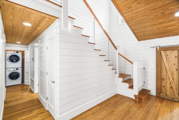 A staircase with wooden steps and a white wall with horizontal lines.