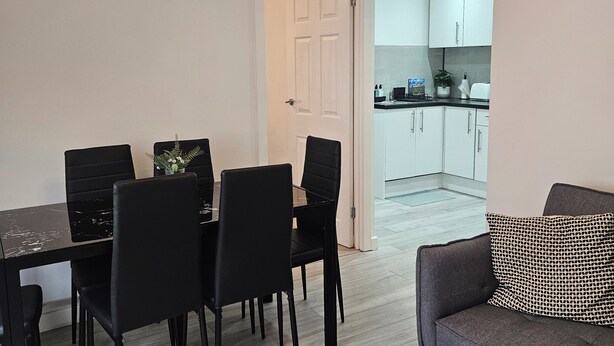 A modern kitchen with white cabinets and a black countertop.