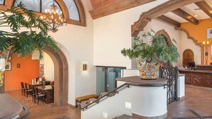 Un hall d’entrée avec un comptoir de réception, un escalier et un espace repas.