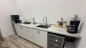 A compact kitchen with a sink, countertop, and a coffee maker.