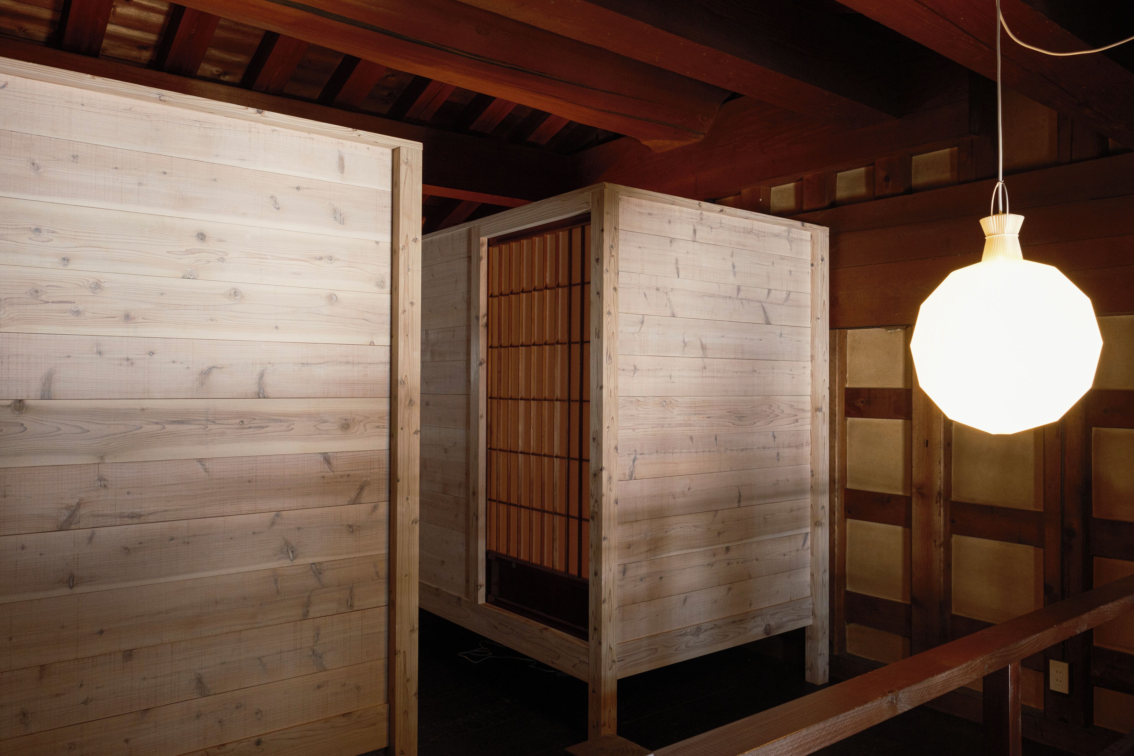 A room with wooden walls and a hanging light fixture.