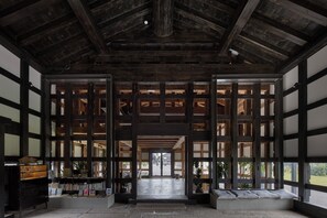 Ein traditionelles japanisches Interieur mit Tatami-Böden, Holzbalken und verschiebbaren Türen.