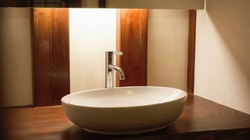 A white ceramic sink with a modern faucet on a wooden countertop.