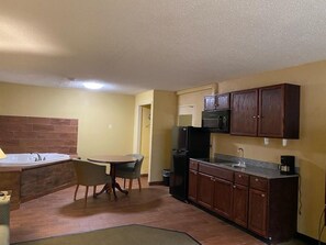 A compact kitchen with a dining area, a built-in oven, and a microwave.