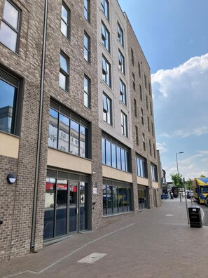 A modern multi-story building with large windows and a brick facade.