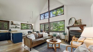 Un amplio salón con chimenea, ventanas grandes y una zona de estar acogedora.