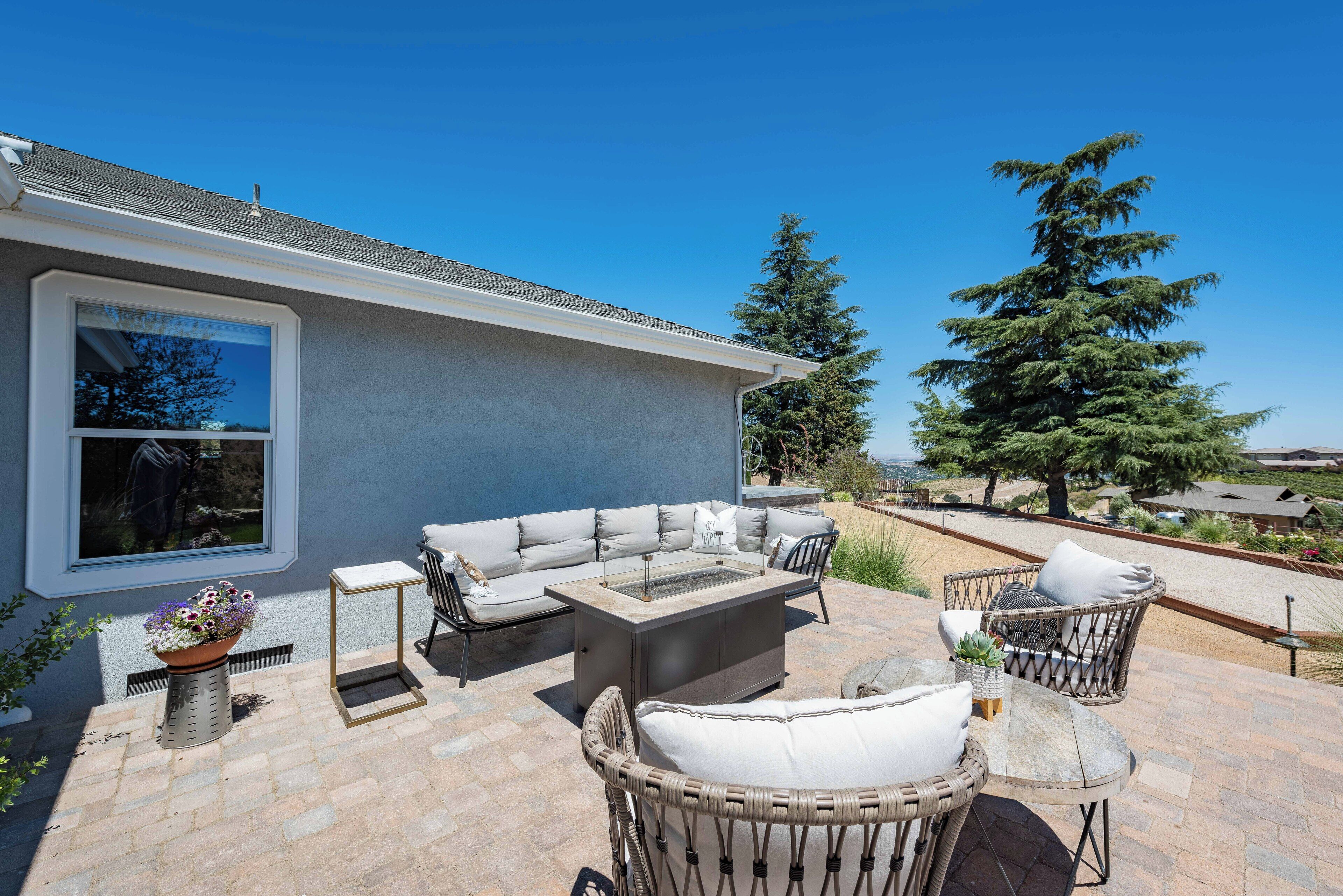 An outdoor patio with a sofa, chairs, and a table.