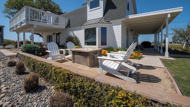 A two-story house with a balcony, outdoor seating area, and a covered porch. - Hidden Acre Vineyard (Paso Robles)