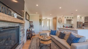 A cozy living room with a fireplace, a sofa, and a coffee table. - Bella Vita (Paso Robles)