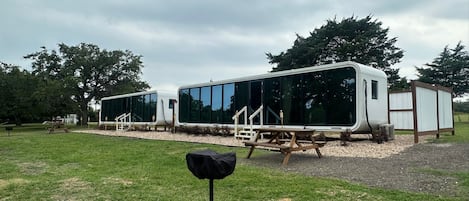 A modern RV-style building with large windows and a covered outdoor area.