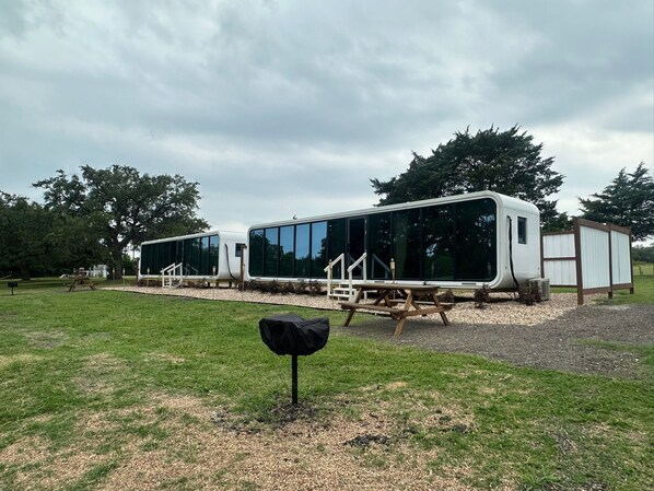 A modern RV-style building with large windows and a covered outdoor area.