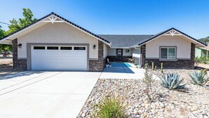 A two-story house with a garage, a front porch, and a swimming pool. - Blue Moon Escape (Paso Robles)