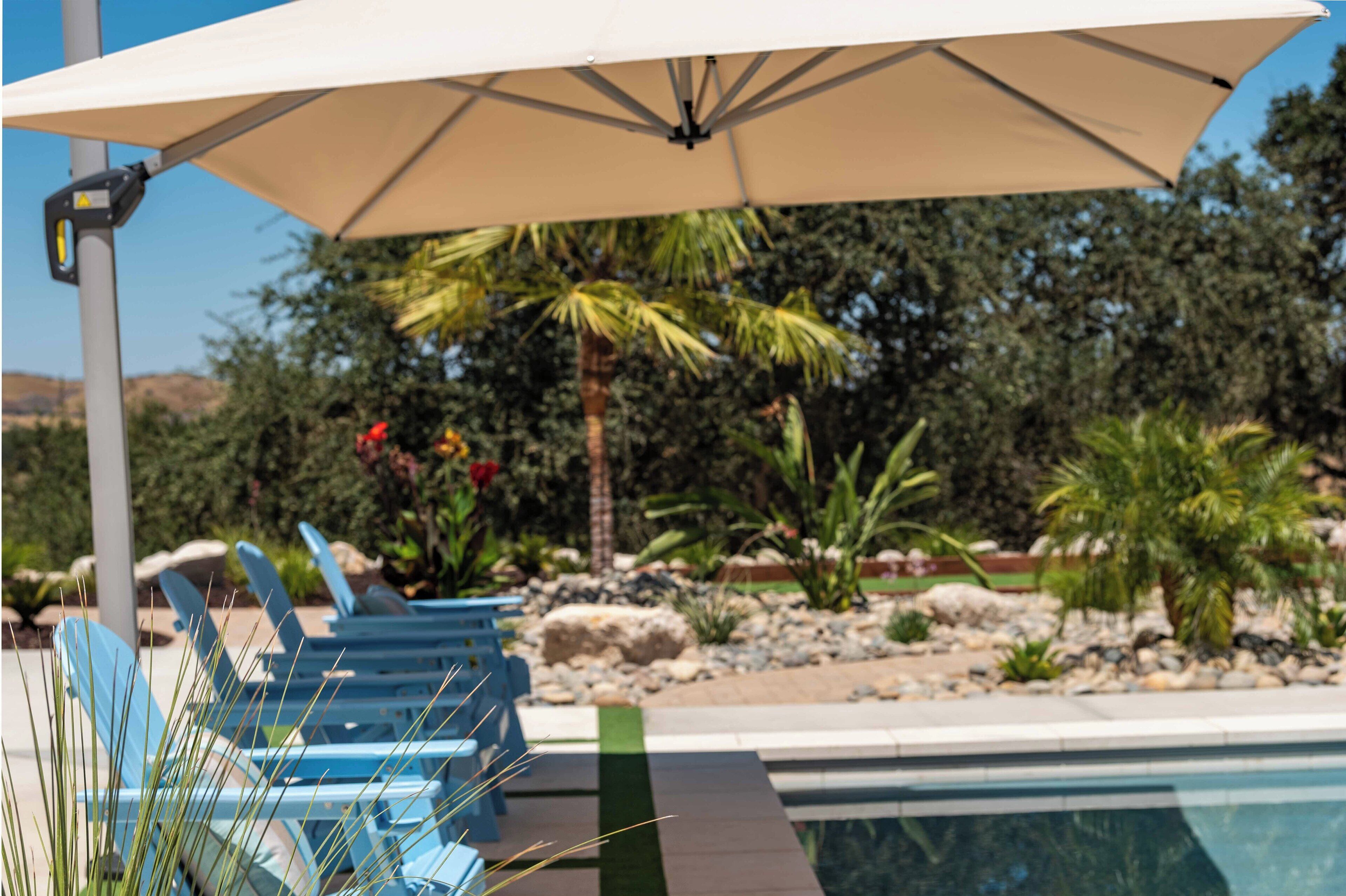 A poolside area with lounge chairs and a large umbrella.