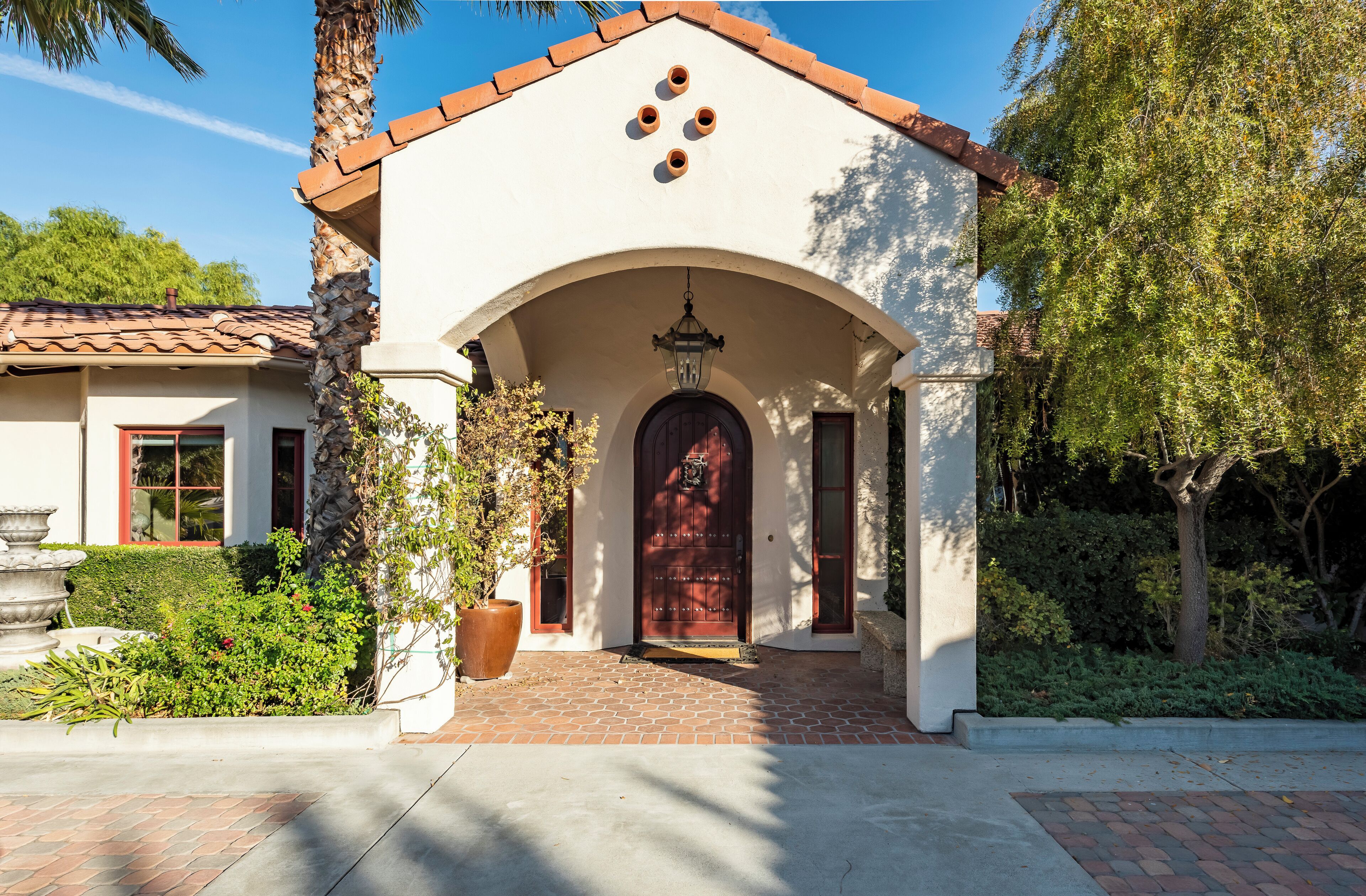 A building with a red door, an arched entrance, and a tiled roof.