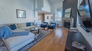 Un salon moderne avec un canapé, des fauteuils, une table basse et une cheminée.