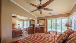 A bedroom with a large bed, a ceiling fan, a dresser, a mirror, and a window with blinds. - Golfer's Getaway (Nipomo)