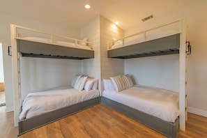 A room with two bunk beds, wooden flooring, and a white wall. - Hilltop Oasis (Templeton)