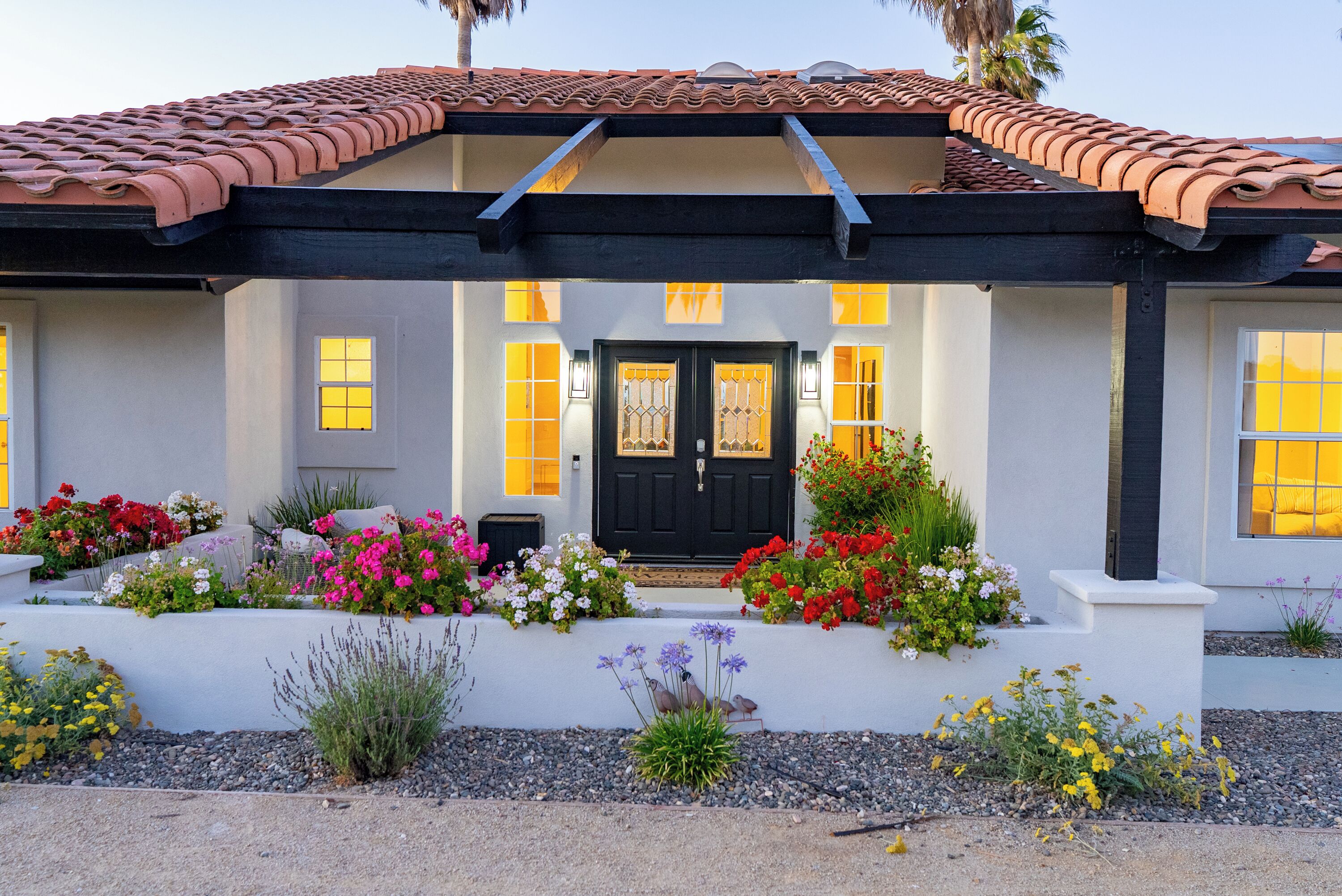 A house with a black door, yellow windows, and a tiled roof.
