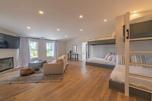 A modern bedroom with a fireplace, bunk beds, a sofa, and a coffee table.