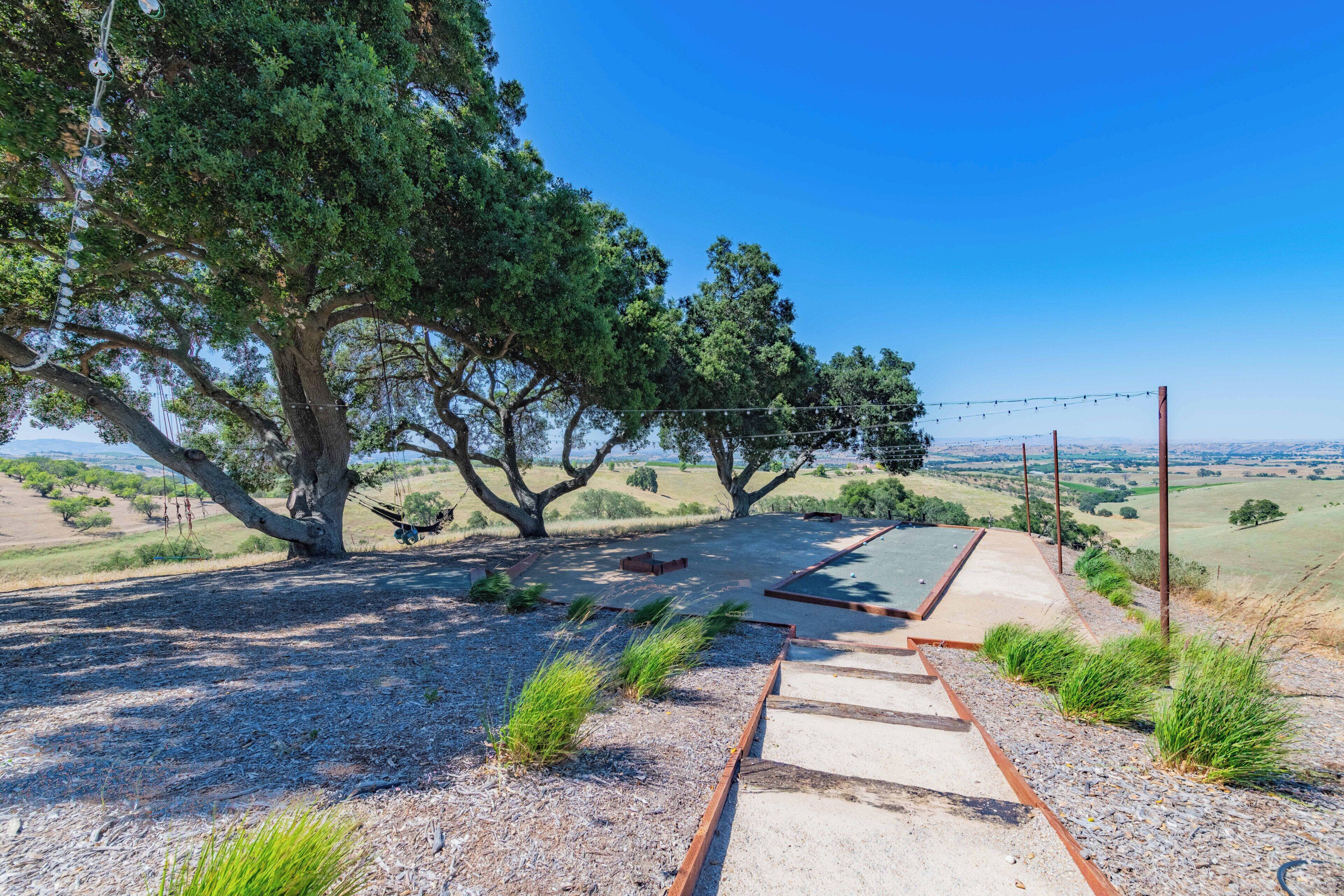 A patio area with a concrete pathway, a hammock, and a view of the countryside.