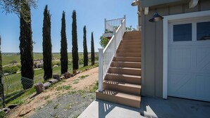 A staircase leading to a garage with a clear view of the surrounding landscape. - Hidden Acre - Bird House (Paso Robles)