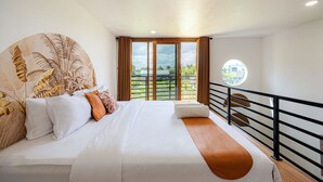 A hotel room with a large bed, a view of the outdoors, and a balcony with a railing. - Cove Kisah Residence (Munggu)