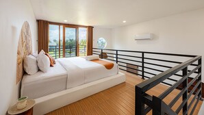 A modern hotel room with a large bed, a view of the outdoors, and a balcony with a railing. - Cove Kisah Residence (Munggu)