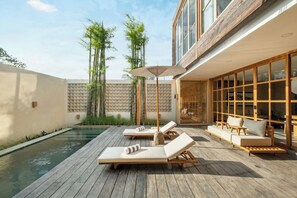 A wooden deck with lounge chairs and a small pool. - Salty Breeze Bingin (Pecatu)