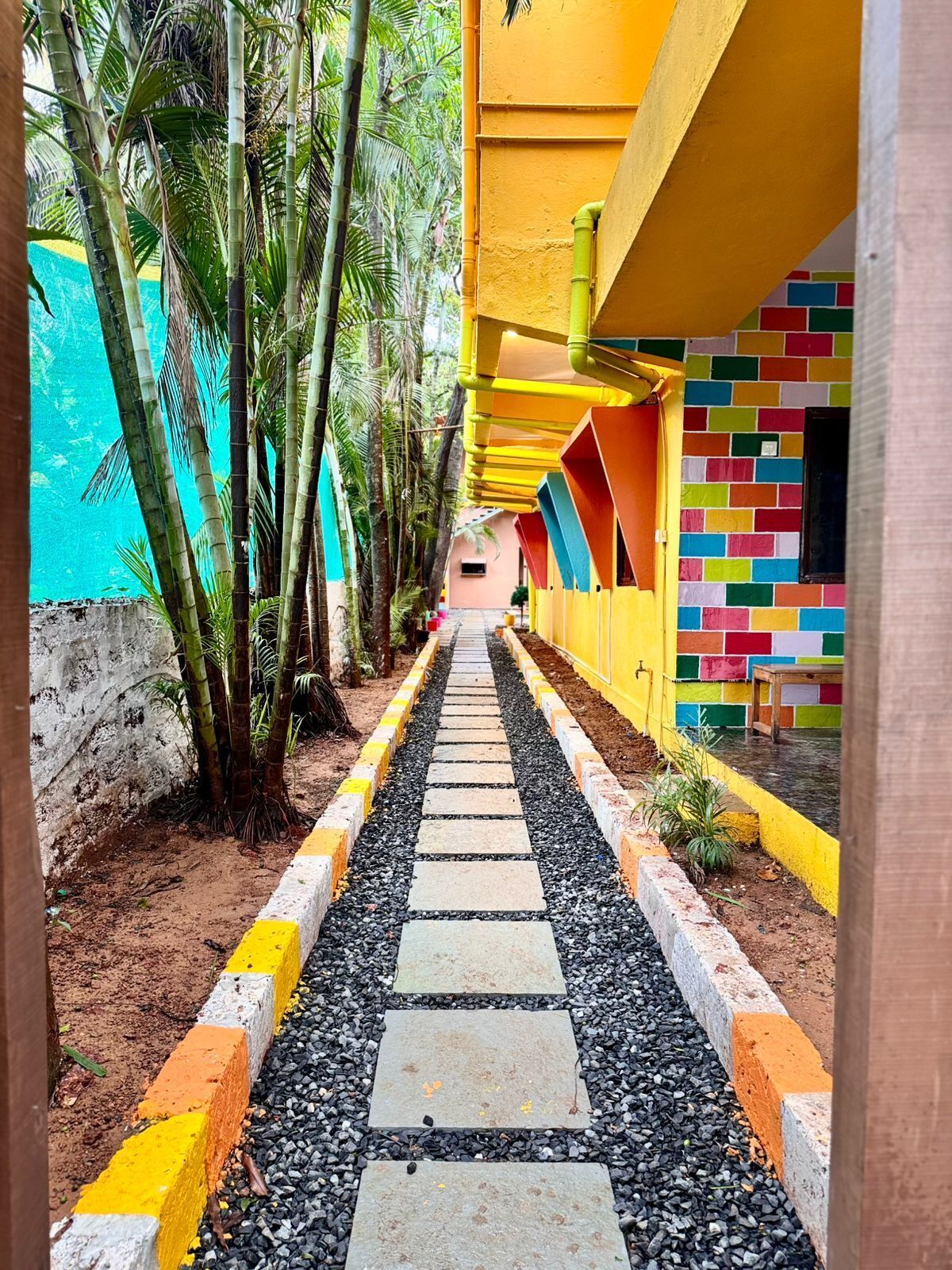 A pathway lined with colorful buildings and bamboo trees.