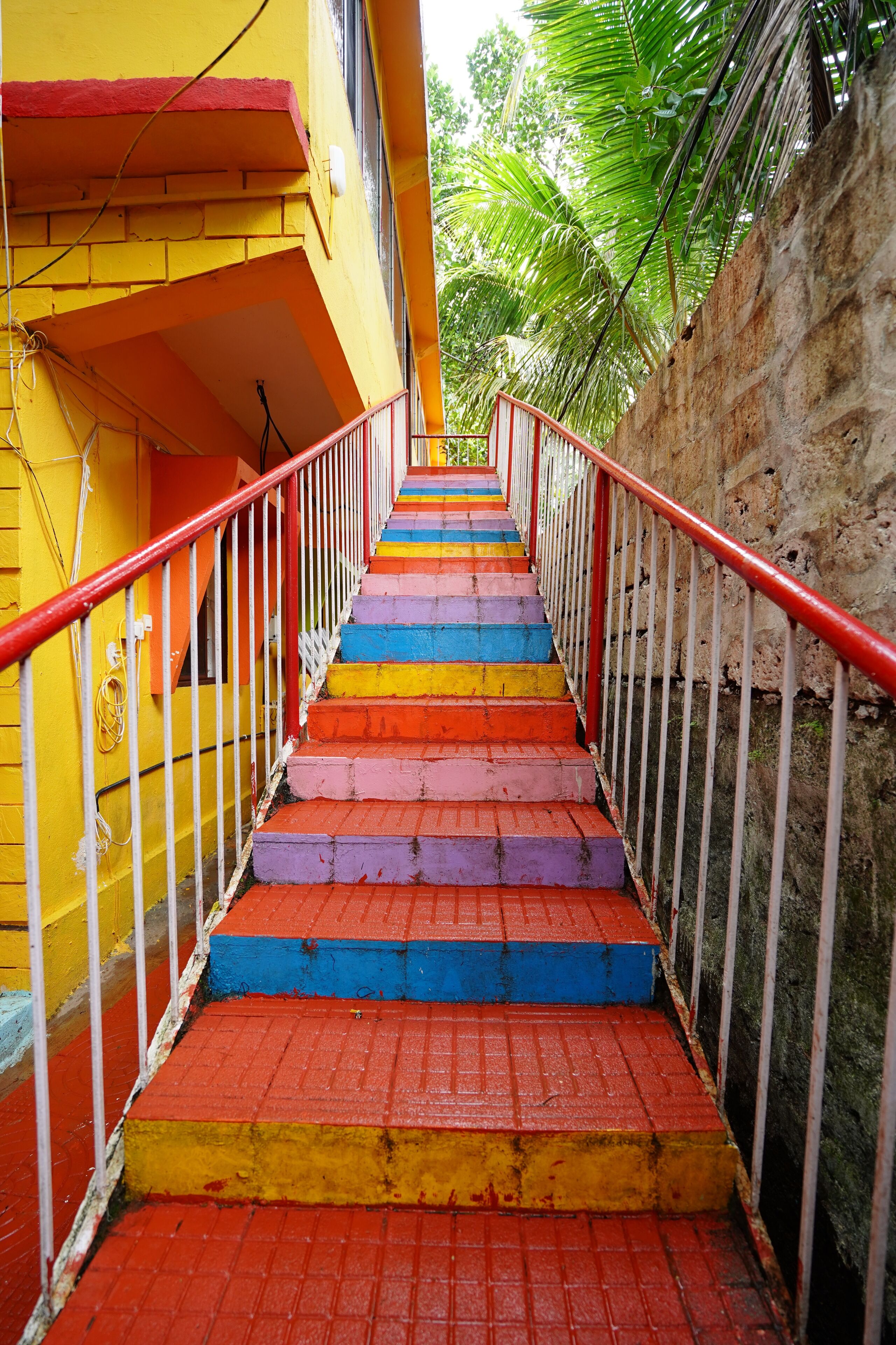 A staircase with colorful steps leading up to a building.